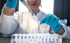 Pipetting into tube Person in PPE pipetting into tube