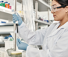 Oligonucleotide Purification Methods for Your Research Scientist in a lab pipetting reagents into a tube
