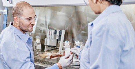 partnership management two scientists at cell processing workbench