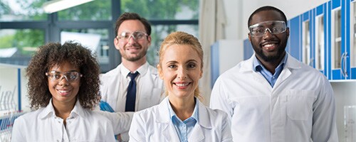 A group of researchers smile at the camera A group of researchers smile at the camera