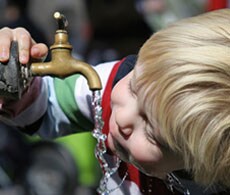 男孩从水龙头饮水 男孩从水龙头饮水