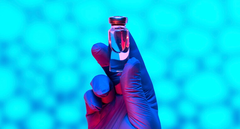 Gloved hand holding a glass vial Gloved hand holding a glass vial