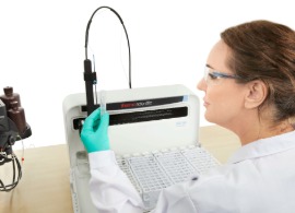 Auto-dilution of ICP-MS samples a woman wearing a lab coat and safety glasses, sitting in front of an autosampler and an iCAP MTX ICP-MS instrument