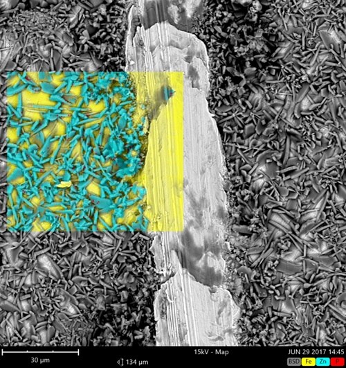 SEM image in backscatter mode of a steel sample covered with zinc phosphate coating overlaid with a colored EDX map, showing the coated (yellow: iron) areas and the coating (light blue: zinc). SEM image in backscatter mode of a steel sample covered with zinc phosphate coating overlaid with a colored EDX map, showing the coated (yellow: iron) areas and the coating (light blue: zinc).